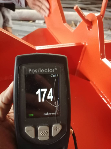 Coating thickness gauge showing 174 microns on painted steel fabrication